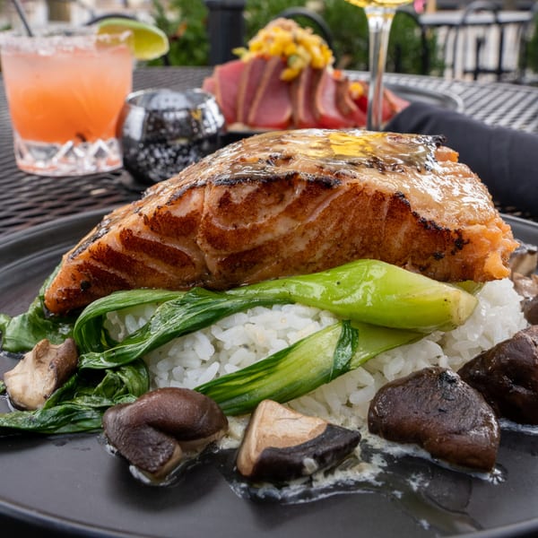 J Liu of Dublin's grilled salmon with bok choy, mushrooms, and rice, with a cocktail and tuna in the background.