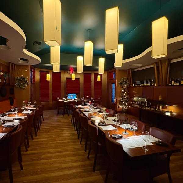 Long dining tables set with glasses and menus under rectangular pendant lights at J Liu of Dublin.